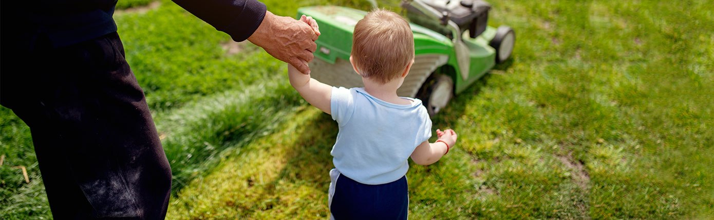 Отец показывает ребёнку газонокосилку